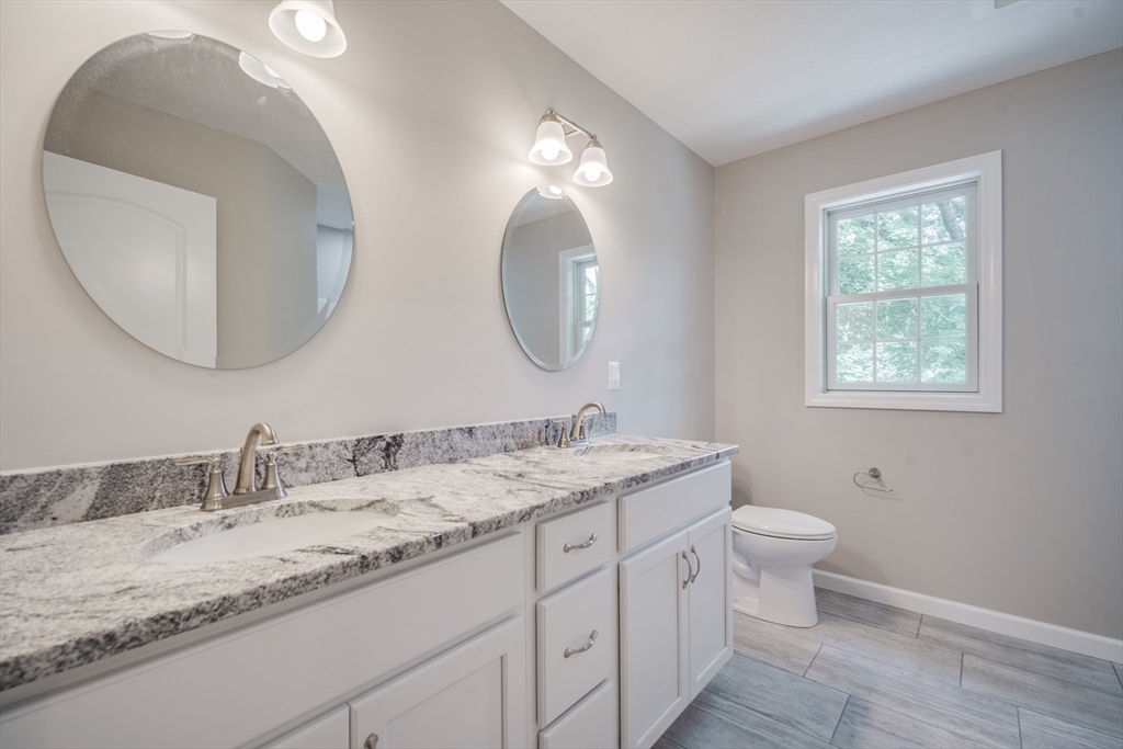 10 Kittrell Street Springfield, MA 01119 - Photo 34 of 42 a bathroom with a granite countertop toilet a sink and a mirror