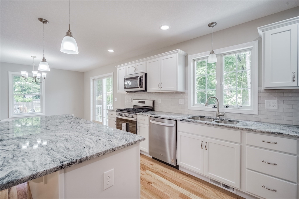10 Kittrell Street Springfield, MA 01119 - Photo 4 of 42 a kitchen with granite countertop kitchen island white cabinets and white appliances