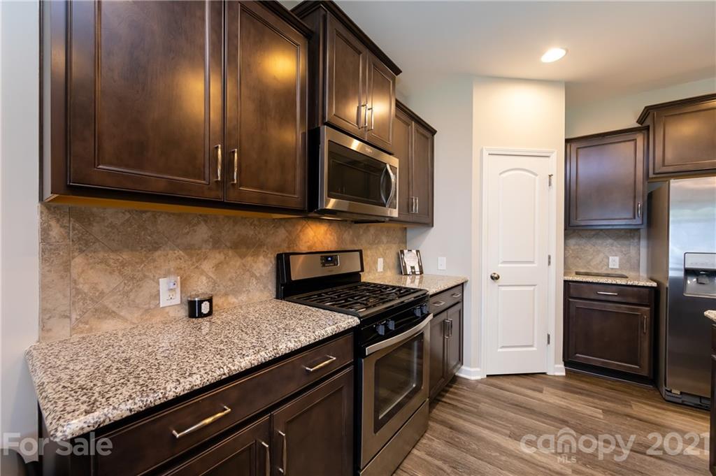 4822 Abendego Road Charlotte, NC 28213 - Photo 14 of 48 a kitchen with granite countertop stainless steel appliances and wooden cabinets