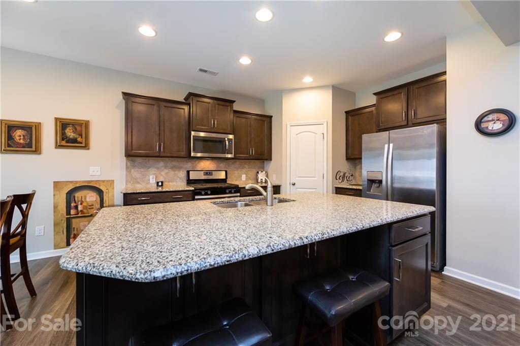 4822 Abendego Road Charlotte, NC 28213 - Photo 15 of 48 a kitchen with kitchen island a refrigerator stove microwave and sink