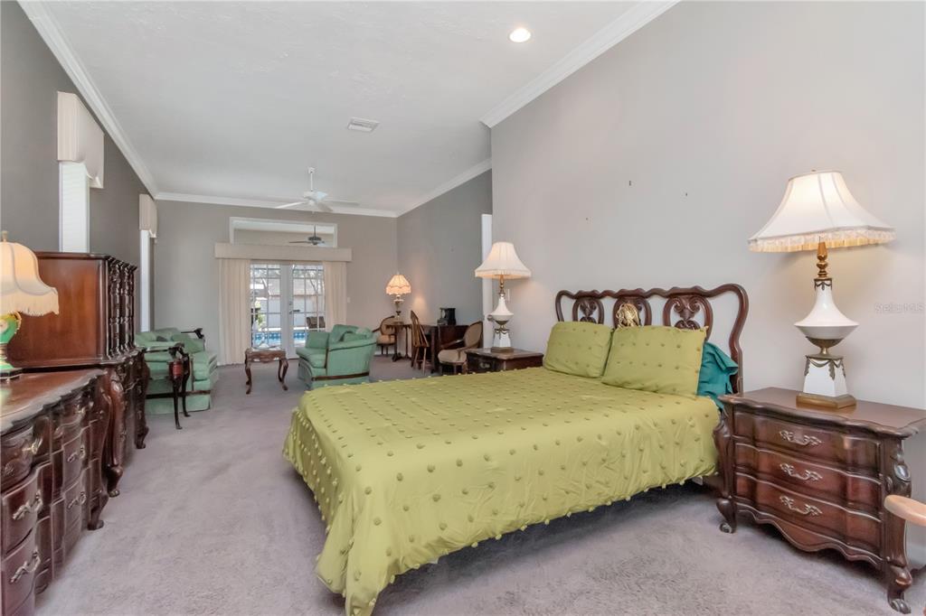 4511 Country Gate Court Valrico, FL 33596 - Photo 24 of 64 a bedroom with a bed and a chandelier