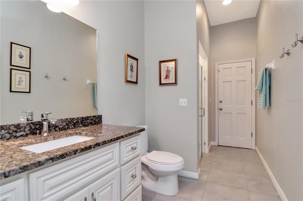 4511 Country Gate Court Valrico, FL 33596 - Photo 30 of 64 a bathroom with a granite countertop sink a toilet and a mirror