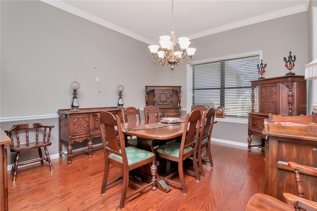 4511 Country Gate Court Valrico, FL 33596 - Photo 50 of 64 a dining room with furniture a chandelier and wooden floor