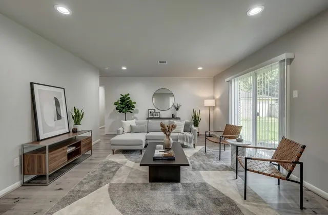 a living room with furniture fireplace and a large window