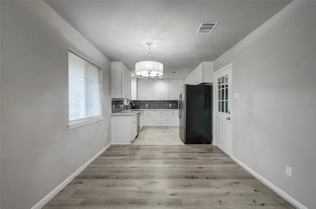 a view of a kitchen with a refrigerator and a chandelier