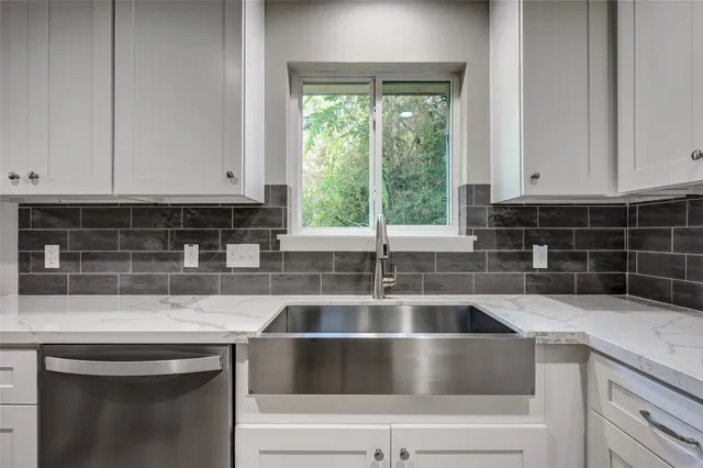 a kitchen with granite countertop a sink and a stove