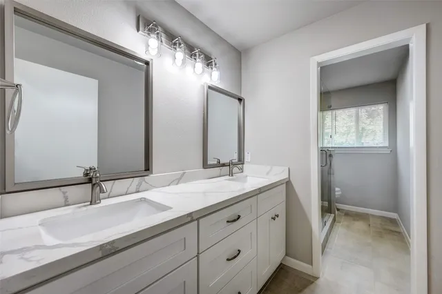 a bathroom with a granite countertop sink double and mirror
