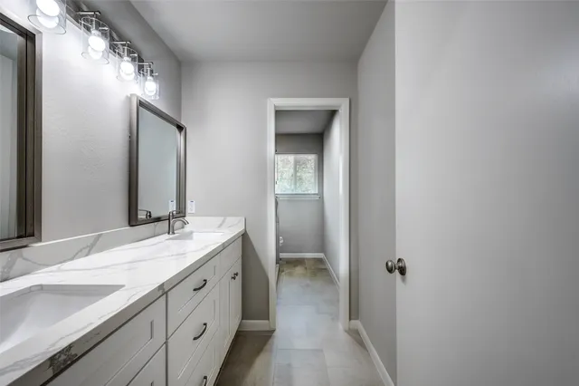 a bathroom with a double vanity sink and mirror