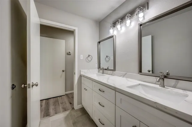 a bathroom with a double vanity sink and a mirror