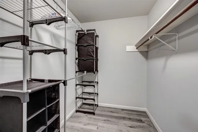a view of walk in closet with empty racks