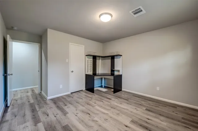 a view of room with window and wooden floor
