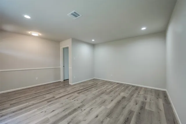 an empty room with wooden floor and white walls