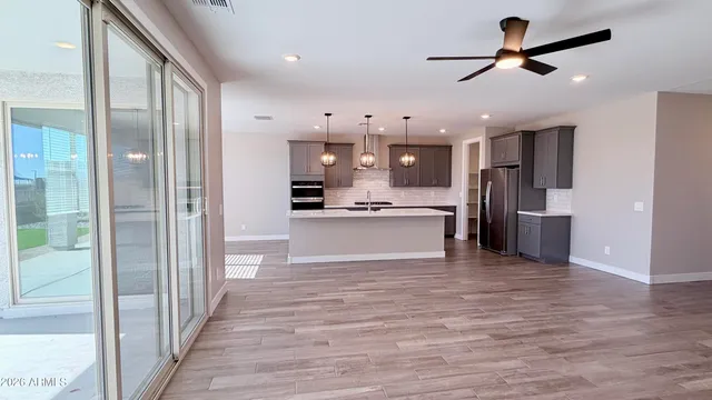 a large kitchen with stainless steel appliances a large counter top a refrigerator and a sink