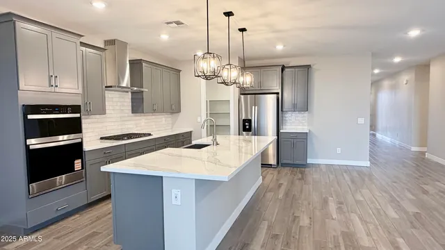 a kitchen with stainless steel appliances granite countertop a sink a microwave a refrigerator and a stove