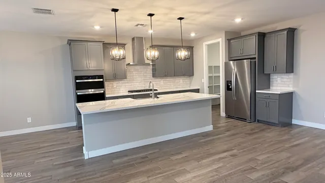 a kitchen with stainless steel appliances granite countertop sink stove and refrigerator