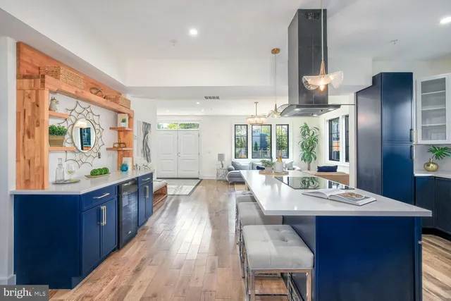 a large kitchen with stainless steel appliances a large window a sink a counter space and wooden floor