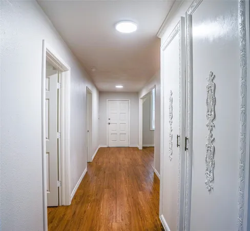 a view of a hallway with wooden floor