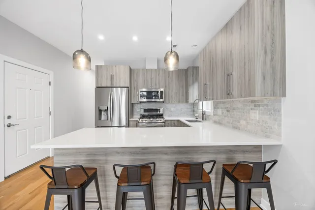 a kitchen with kitchen island a sink stove and refrigerator