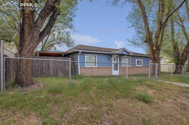 a view of a yard in front of a house with large trees