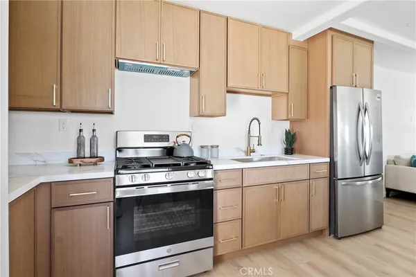a kitchen with stainless steel appliances granite countertop a stove a refrigerator and a sink