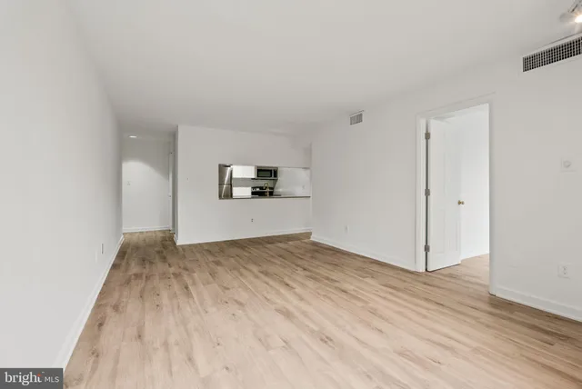 a view of empty room with wooden floor