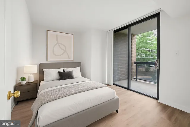 a bedroom with a bed and a large window