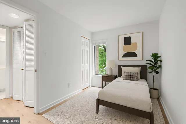 a bedroom with a bed and a potted plant