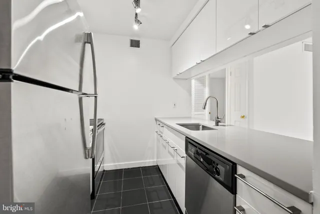 a kitchen with a sink a refrigerator a washer and dryer