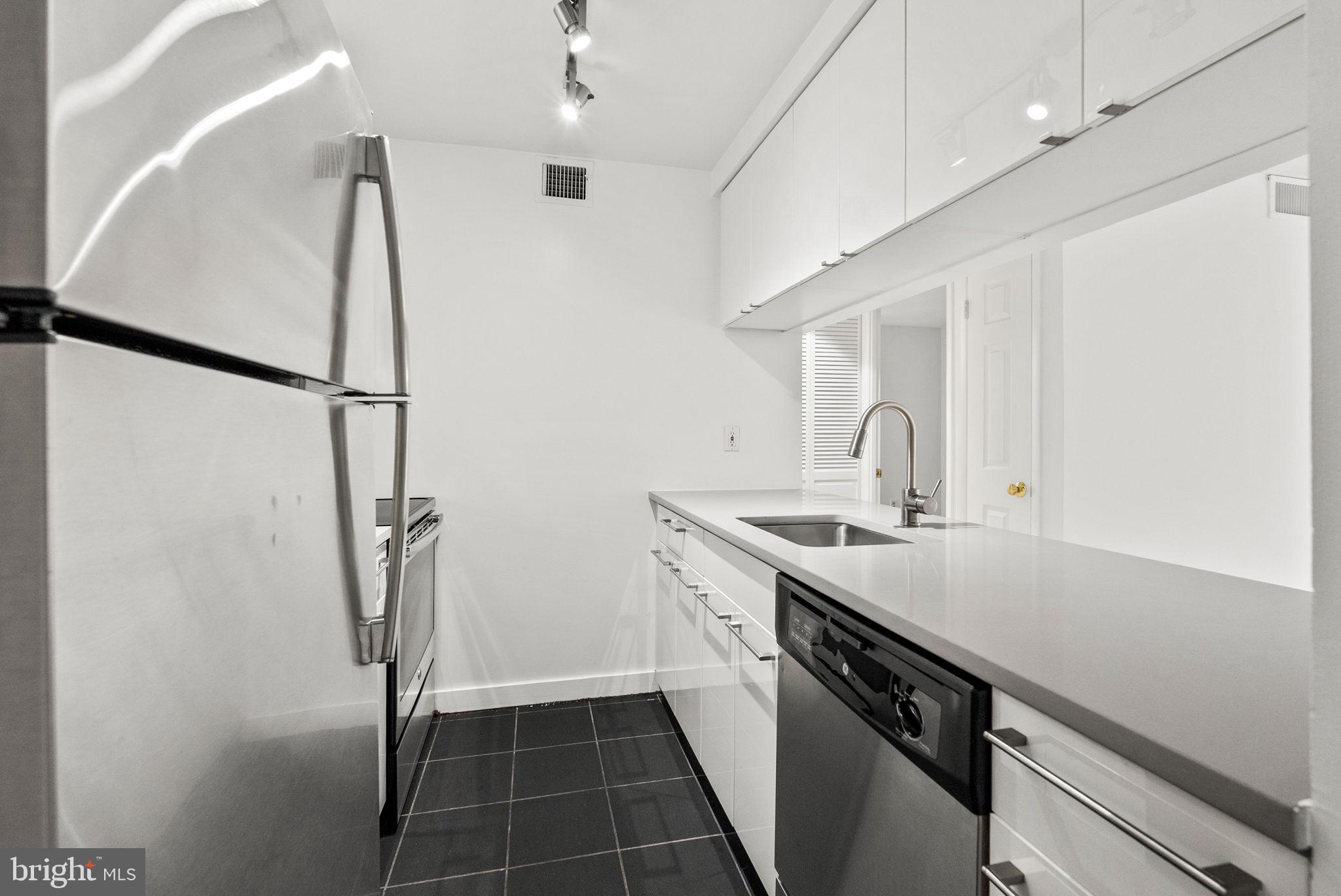 601 24th Street Northwest, Unit 306 Washington, DC 20037 - Photo 8 of 34 a kitchen with a sink a refrigerator a washer and dryer