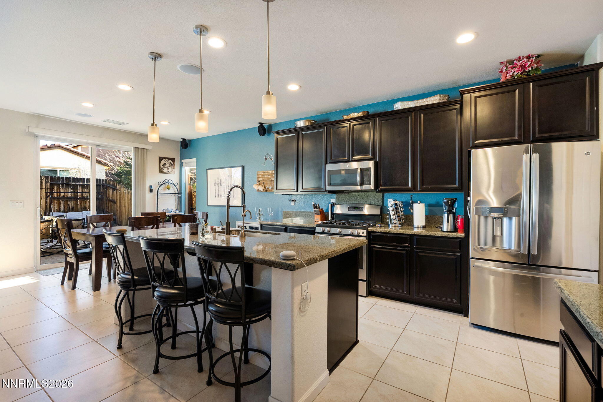 2190 Dutch Draft Drive Reno, NV 89521 - Photo 13 of 32 a kitchen with stainless steel appliances granite countertop a refrigerator a stove a sink a dining table and chairs