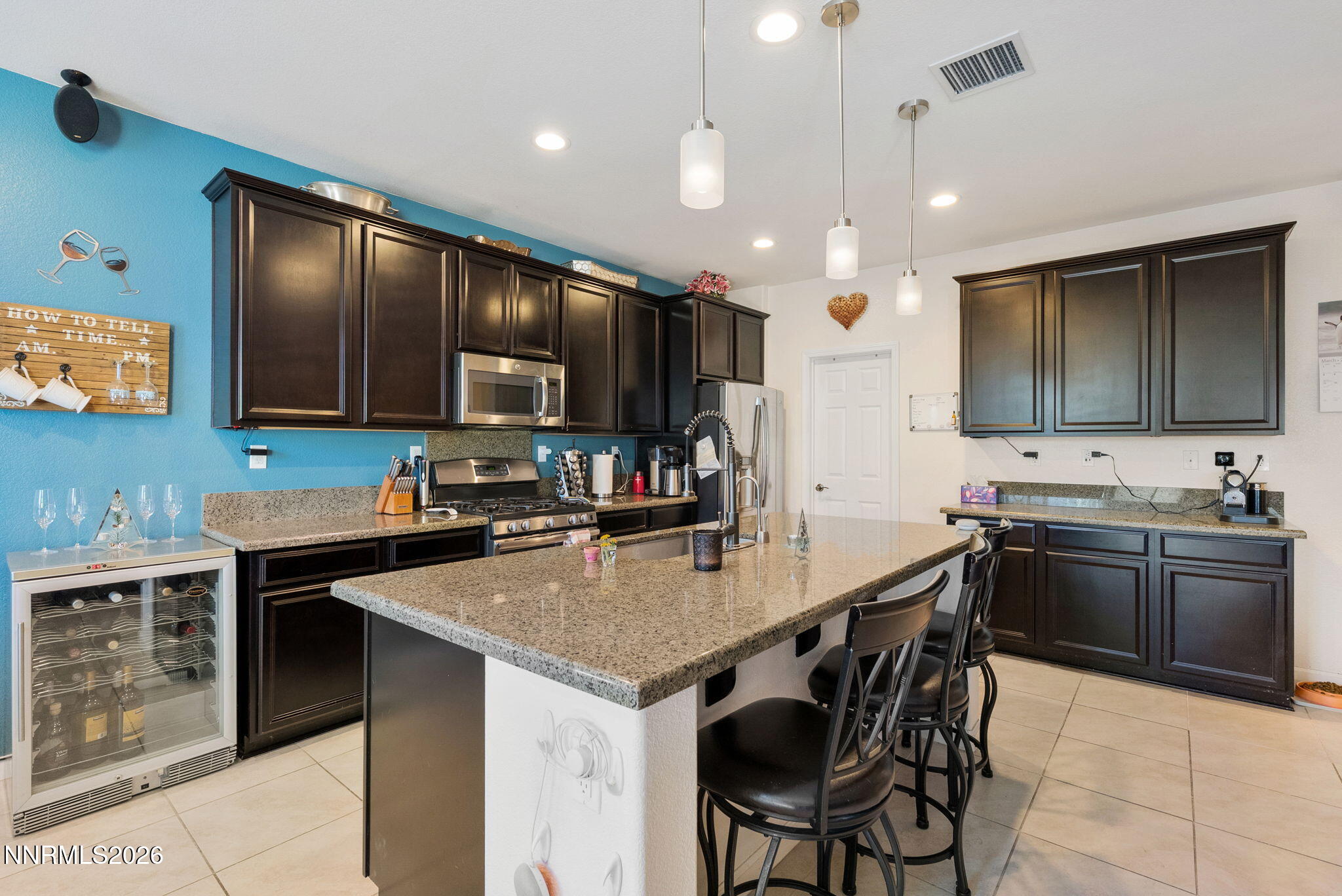 2190 Dutch Draft Drive Reno, NV 89521 - Photo 15 of 32 a kitchen with stainless steel appliances granite countertop a stove top oven a sink dishwasher a dining table and chairs