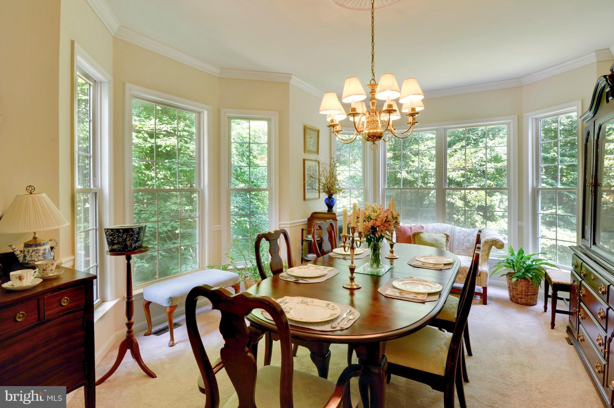 885 Carson Road Huntingtown, MD 20639 - Photo 13 of 30 a view of a dining room with furniture a chandelier and large windows