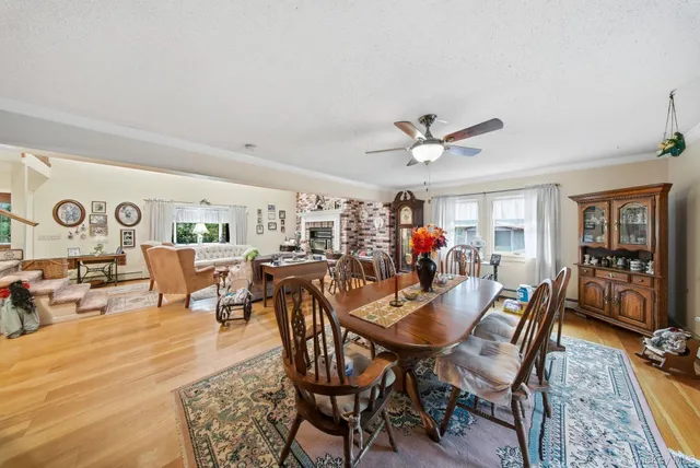 a view of a dining room and livingroom with furniture wooden floor a rug a flat screen tv a rug and a chandelier