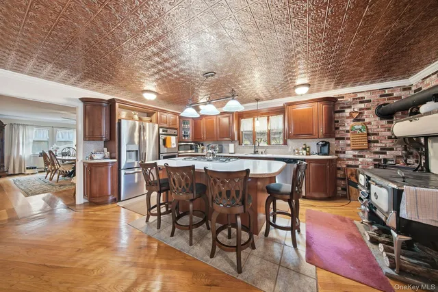 a dining room with stainless steel appliances kitchen island granite countertop a table chairs and a living room view