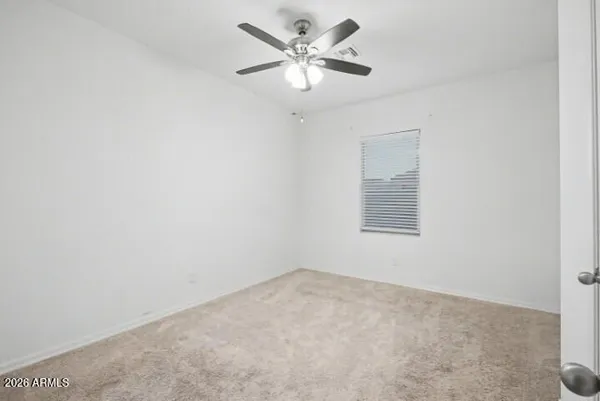 an empty room with a window and a fan