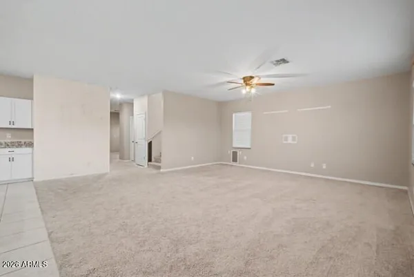 an empty room with windows and fan