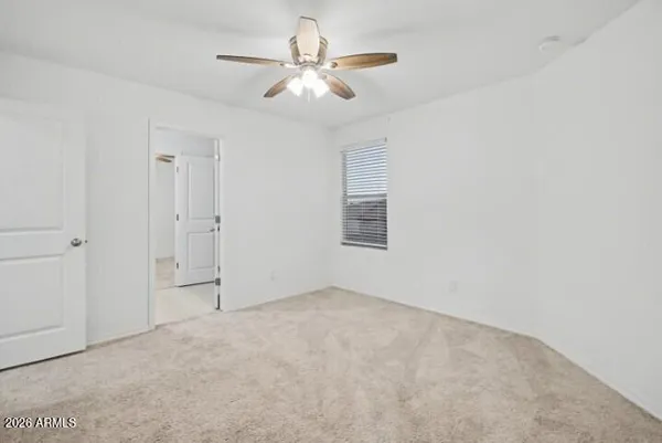 an empty room with closet and a chandelier fan