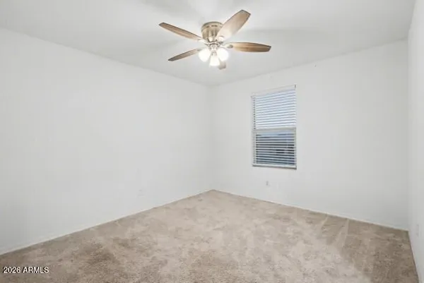 an empty room with a chandelier fan
