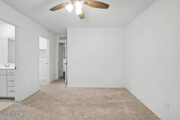 an empty room with a window and a ceiling fan
