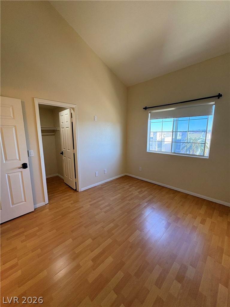 1685 Strasbourg Way, Unit 1685 Henderson, NV 89014 - Photo 15 of 22 Unfurnished bedroom with a spacious closet, vaulted ceiling, and light wood finished floors