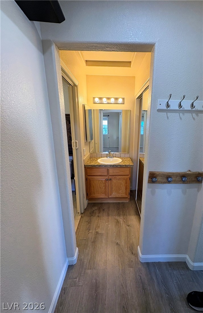 1685 Strasbourg Way, Unit 1685 Henderson, NV 89014 - Photo 17 of 22 Bathroom featuring a textured wall, vanity, and dark wood-type flooring