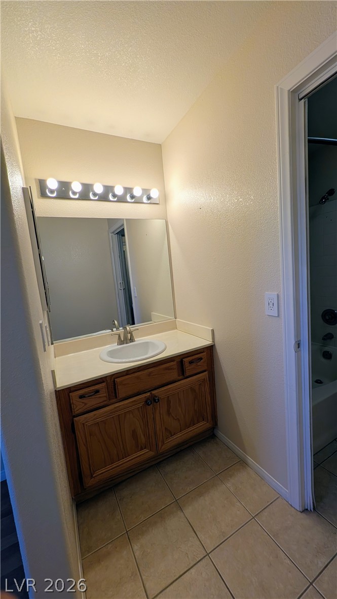 1685 Strasbourg Way, Unit 1685 Henderson, NV 89014 - Photo 18 of 22 Full bathroom with vanity, light tile patterned floors, a textured ceiling, a textured wall, and bathtub / shower combination