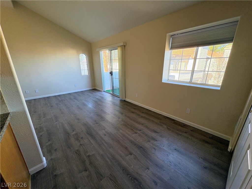 1685 Strasbourg Way, Unit 1685 Henderson, NV 89014 - Photo 3 of 22 Unfurnished room featuring dark wood finished floors, plenty of natural light, and lofted ceiling