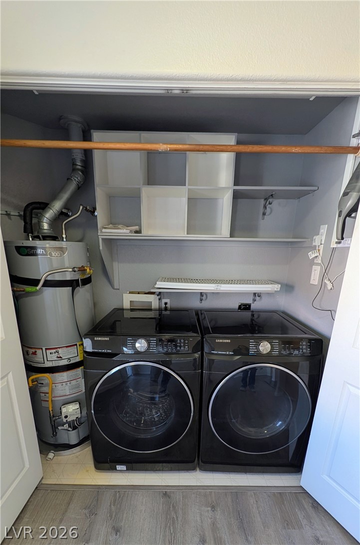 1685 Strasbourg Way, Unit 1685 Henderson, NV 89014 - Photo 10 of 22 Laundry area with water heater, washer and dryer, and light wood-type flooring