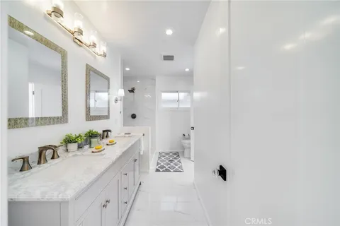 a bathroom with a granite countertop sink a large mirror and shower