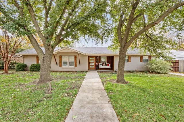 front view of a house and a yard and trees