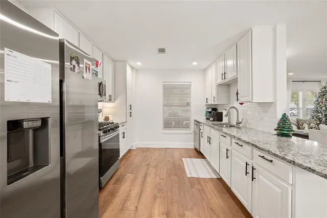 a large kitchen with a large window a sink and stainless steel appliances