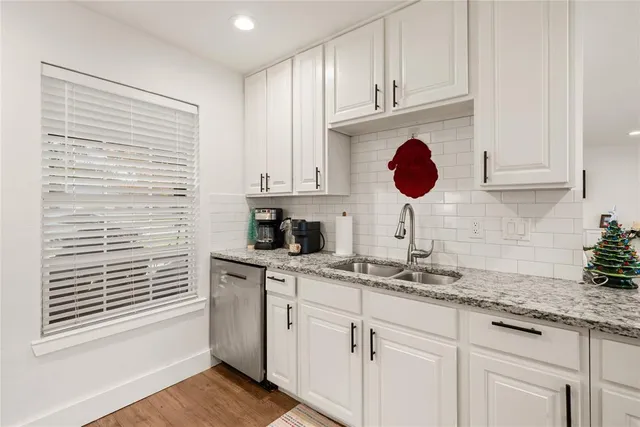 a kitchen with stainless steel appliances granite countertop a sink a stove and cabinets