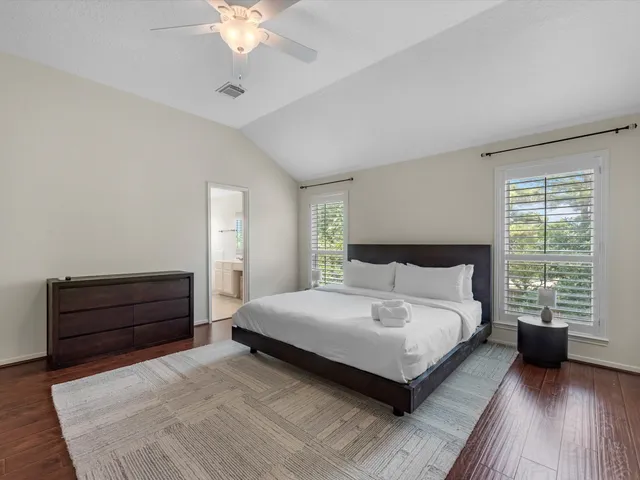 a spacious bedroom with a large bed and a chandelier