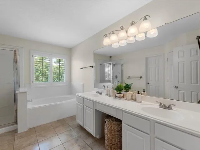 a bathroom with a sink double vanity mirror and a bathtub